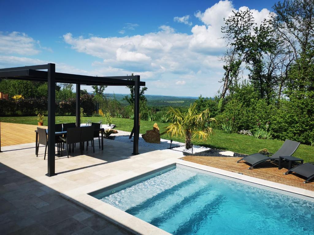 a patio with a pool and a table and chairs at "Notre Bastide" Maison et table d'hôtes traditionnelle et végétarienne, Piscine, jacuzzi, Clim, , à 5 mn de SARLAT in Marcillac-Saint-Quentin