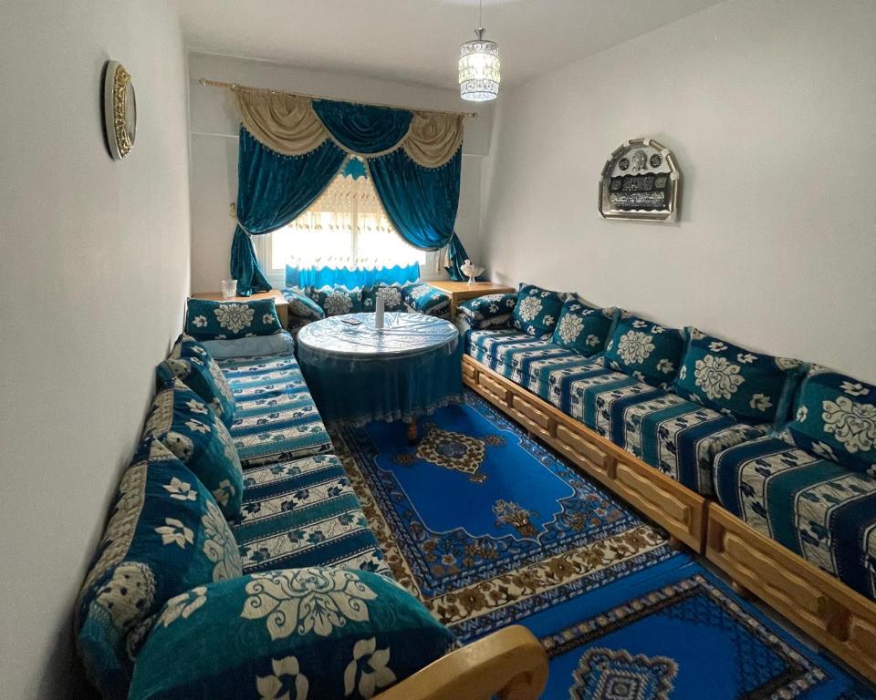 a living room with couches and a table at Appartement Familial Al Hoceima WiFi in Al Hoceïma