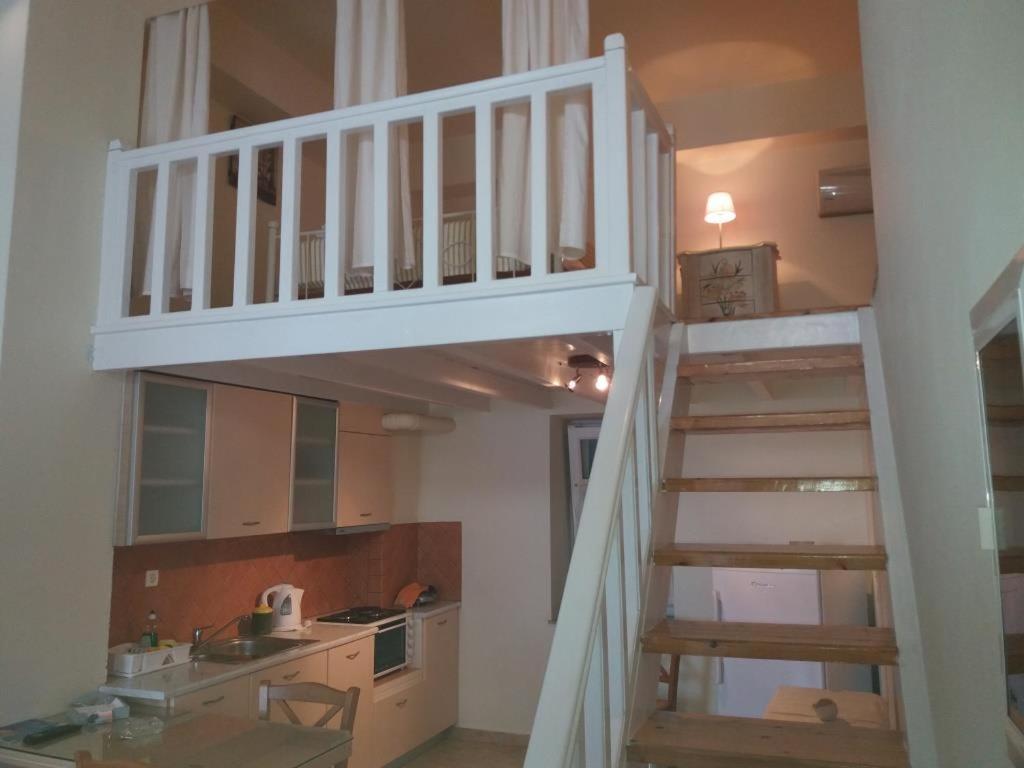 eine weiße Treppe in einem Zimmer mit einer Küche in der Unterkunft Roula's Suites in Ándros