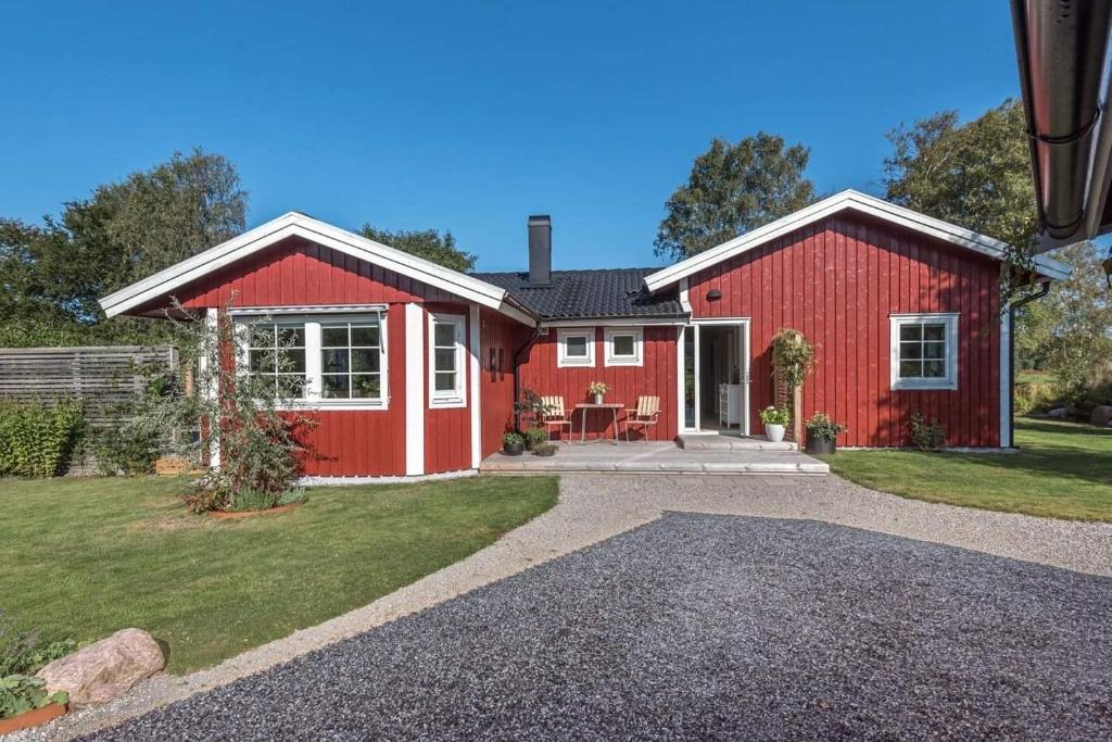 a red house with a gravel driveway at Fjällbacka Villa in Fjällbacka