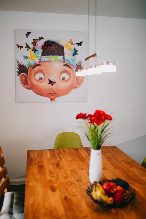 特拉本特拉巴赫Rieslingresidenz的一张木桌上放着一个花瓶，花瓶上画着一张人脸。