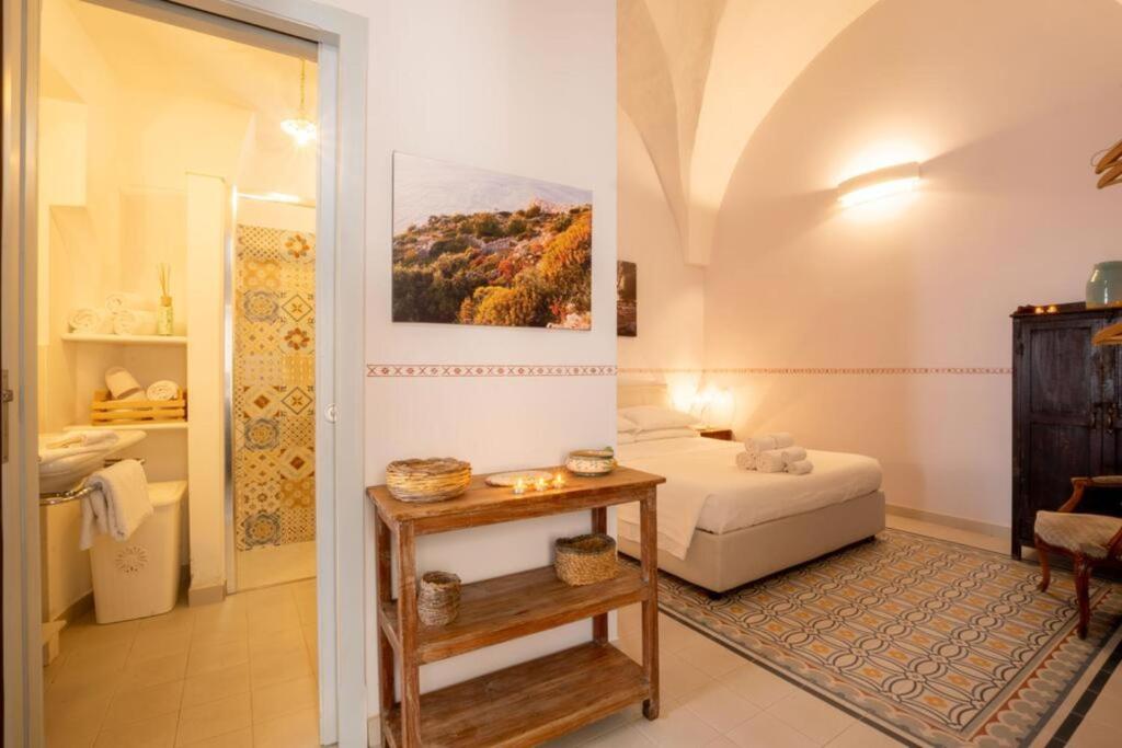 a small room with a bed and a table at Le Viùzze Apartment in Tricase