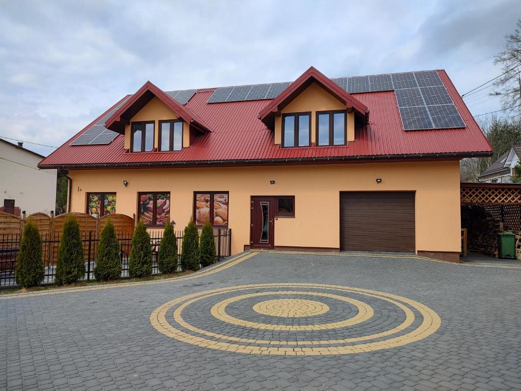 dom z panelami słonecznymi na dachu w obiekcie Pokoje U lalusia w Muszynie