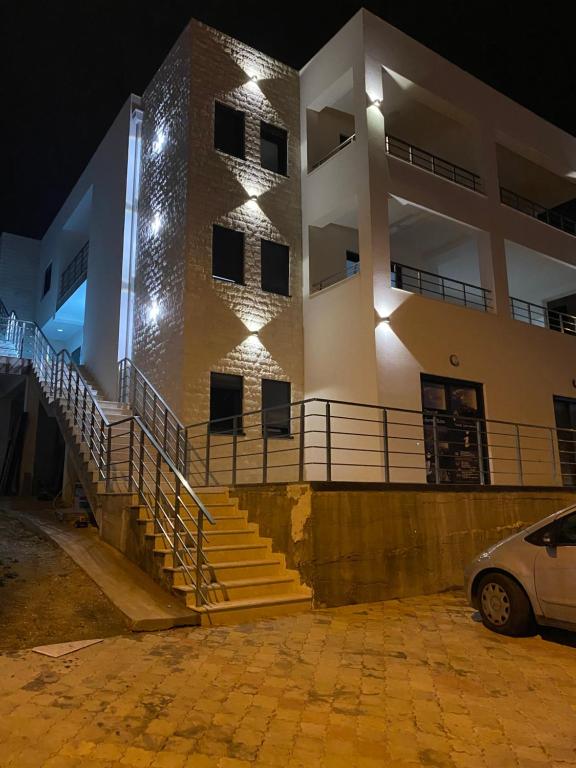 a building with stairs in front of it at night at Xhan Apartments in Ulcinj
