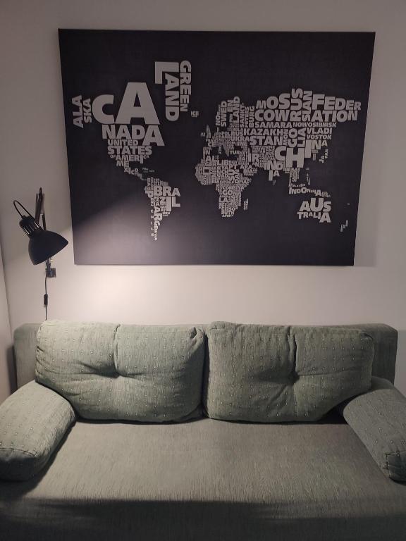 a couch in a living room with a map of the world at Apartman Dux 2 in Karlovac