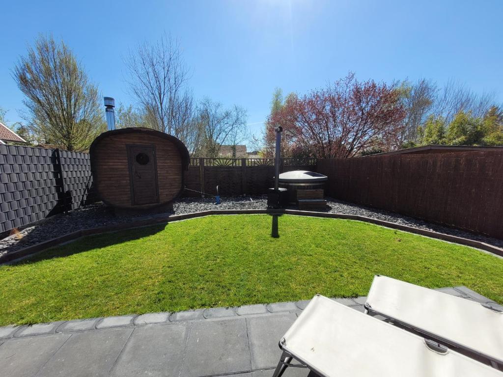a backyard with a dog house and a lawn at Ferienbutze in Molbergen
