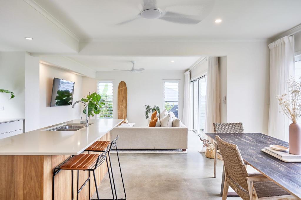 a kitchen and living room with a table and a couch at Sunsets at Epic Lennox Head in Lennox Head