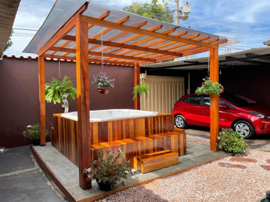 uma pérgola de madeira com uma banheira numa garagem em Cantinho Santiago em Alto Paraíso de Goiás