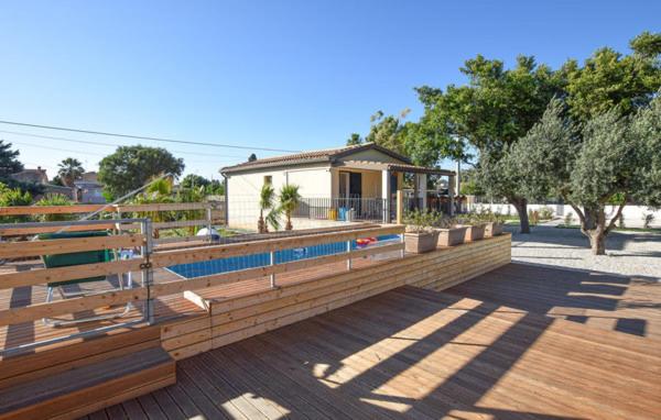 eine Holzterrasse mit einem Pool und einem Haus in der Unterkunft Villetta Gaia in Marina di Ragusa