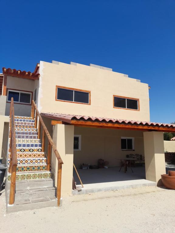 a house with a staircase in front of it at BAJA SUITES UPSTAIRS in Punta Abreojos