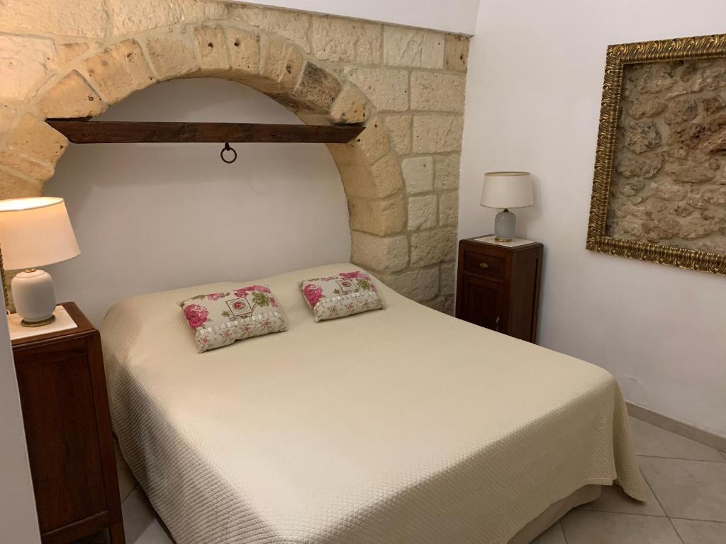 ein Schlafzimmer mit einem Bett mit zwei Kissen darauf in der Unterkunft Duomo Apartment in Nardò