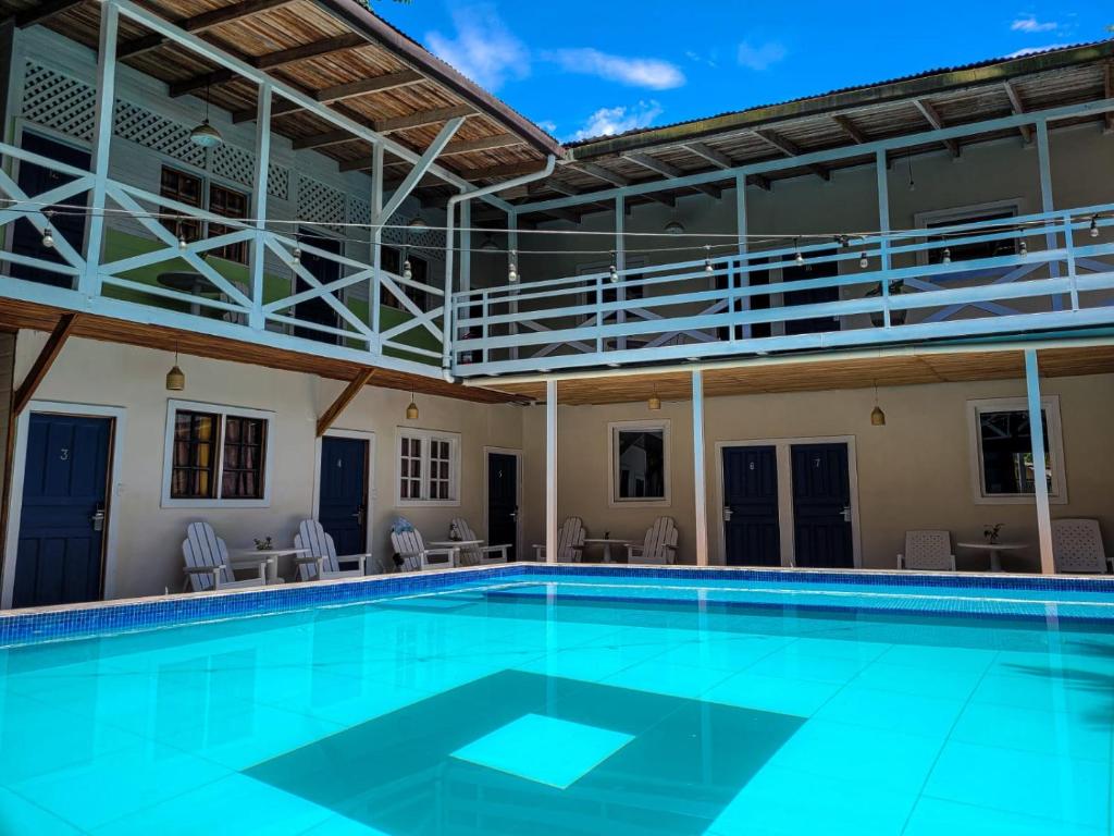 a swimming pool in a building with chairs and tables at Lizard King Hotel & Suites in Puerto Viejo