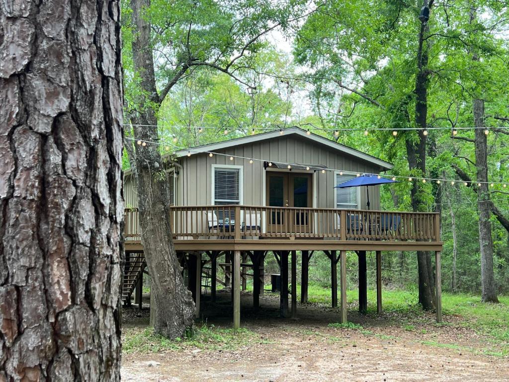 a house on a wooden deck in the woods at 2 BDRM Treehouse Hideout- Lake Conroe with Boat ramp in Montgomery