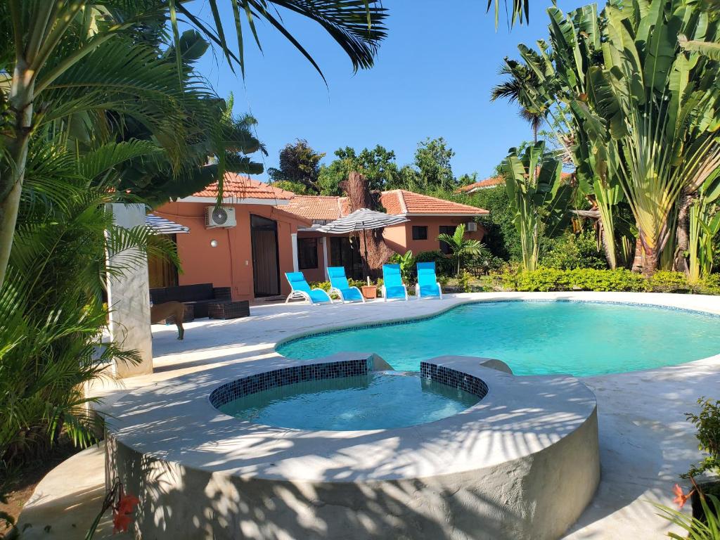 uma piscina num quintal com cadeiras e uma casa em Villas Vargas em Sosúa