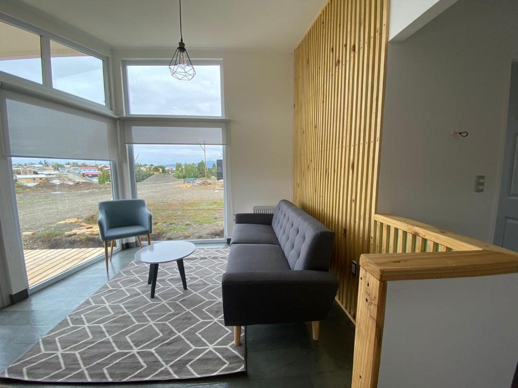 uma sala de estar com um sofá e uma cadeira em CABAÑAS PAMPAS AUSTRALES em Puerto Natales