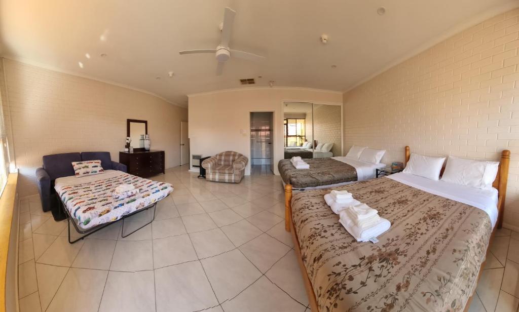 Tuggeranong Short Stay #10 - Sleeps 6 في Tuggeranong: غرفة كبيرة بسريرين واريكة