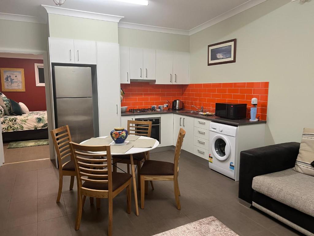 uma cozinha e sala de estar com mesa e cadeiras em Urban Retreat em Wollongong