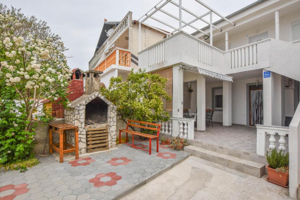 a house with a stone fireplace in the yard at Apartment Rota in Turanj