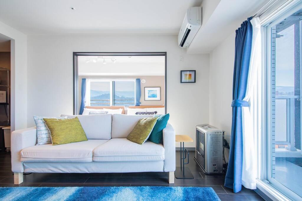 sala de estar con sofá blanco y ventana en GREE en Otaru