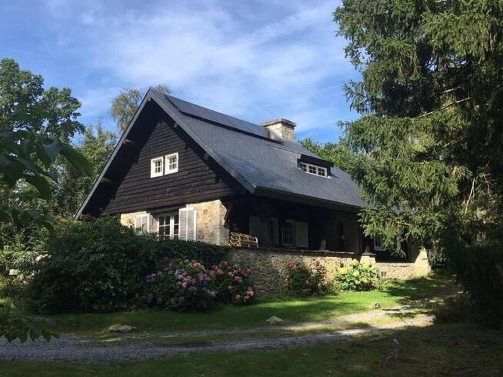 une maison avec un toit noir sur une cour dans l'établissement Quietly located country house in Vielsalm, à Vielsalm