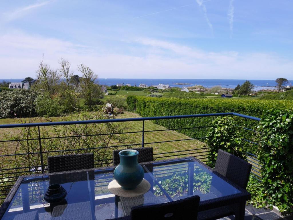 un jarrón sentado en una mesa de cristal en un balcón en Holiday home with sea views, Lampaul-Plouarzel en Lampaul-Plouarzel