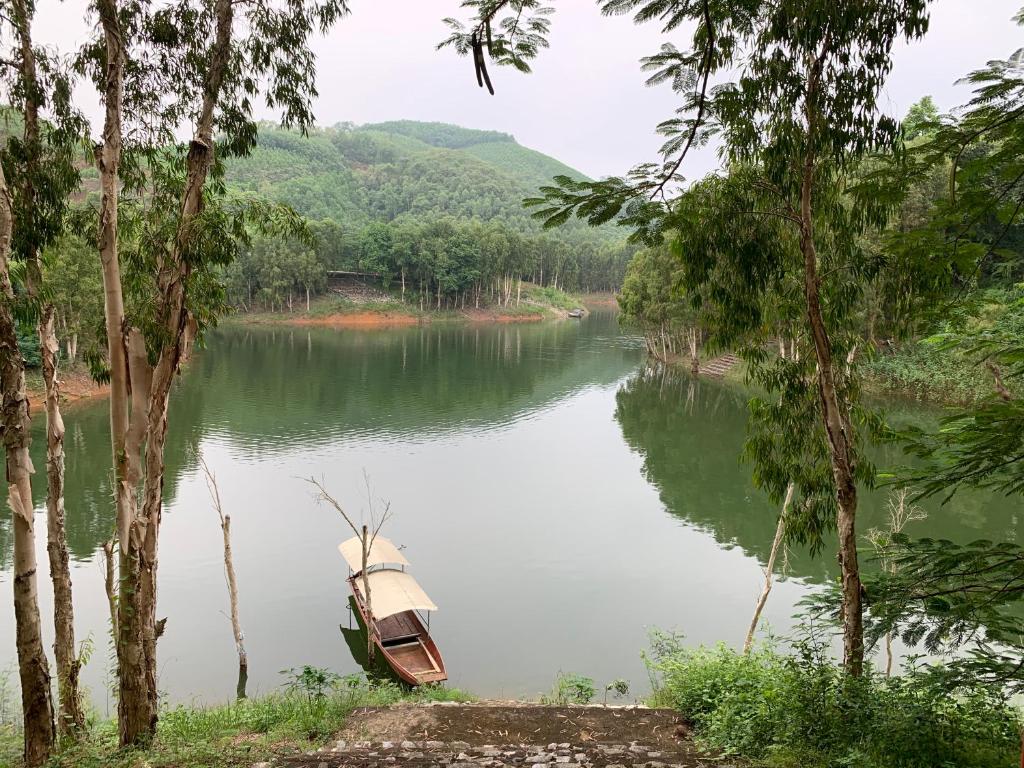 Yên BìnhにあるKhu nghỉ dưỡng Làng An Bìnhの川の中に座る船