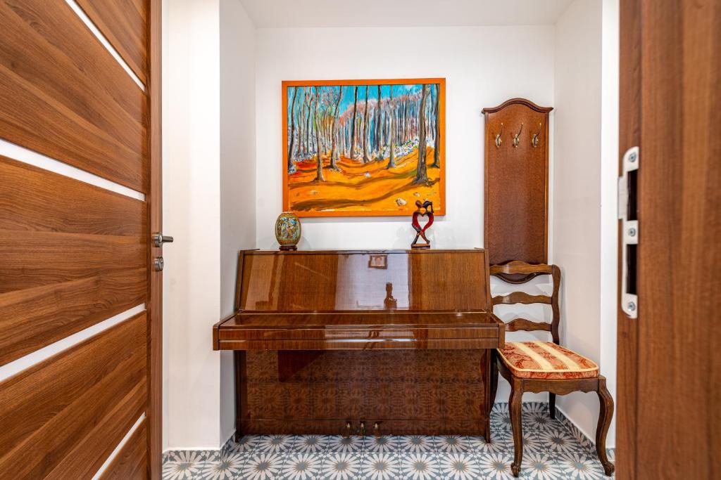 a room with a piano and a chair and a painting at IDA ARTS APARTMENTS in Zadar