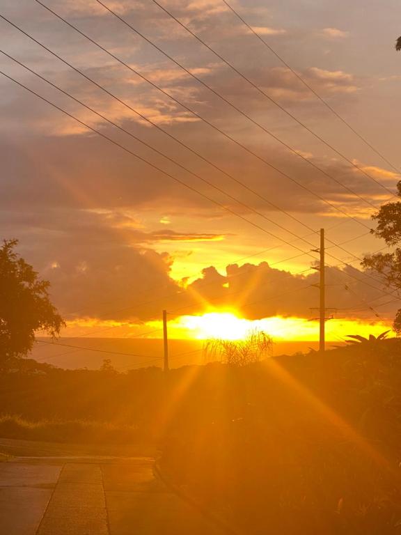 a sunset over a road with the sun setting at Ocean View Oasis, Coffs Harbour in Coffs Harbour