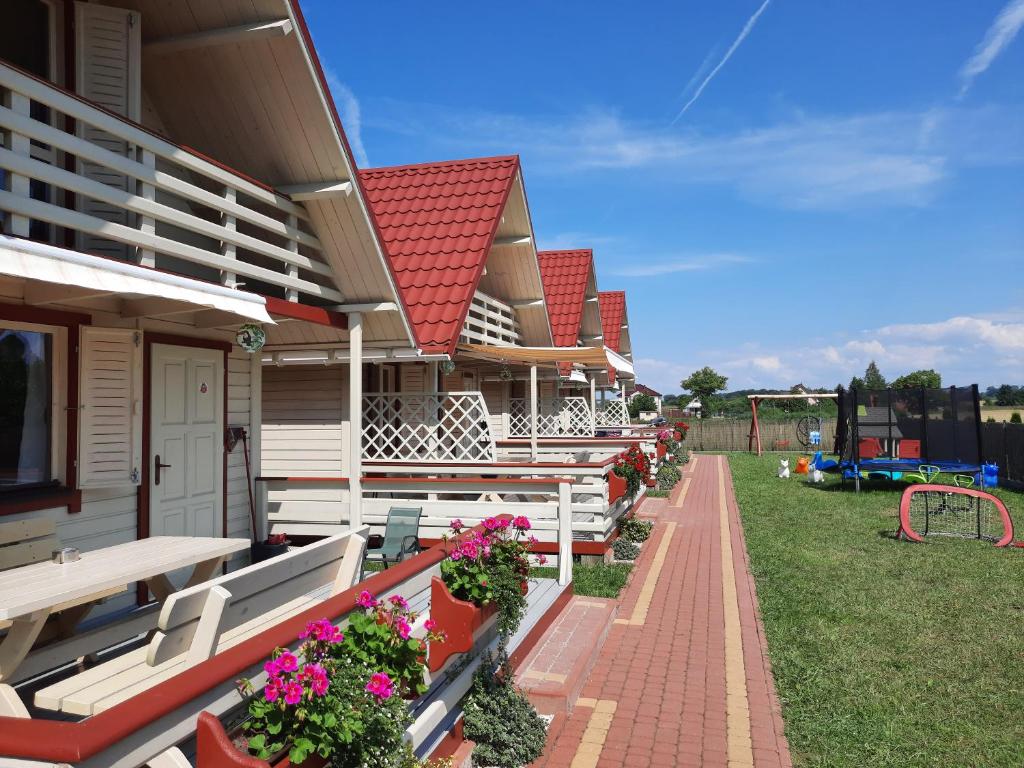 une rangée de bancs sur une maison avec une aire de jeux dans l'établissement Hals domki letniskowe, à Ustronie Morskie