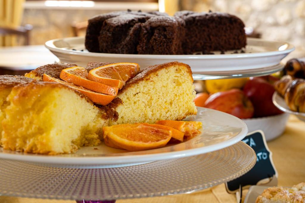 two plates of bread with orange slices on a table at Casale Ginisara in Castellammare del Golfo