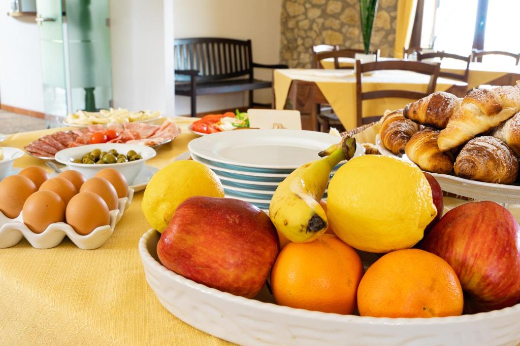 a table topped with bowls of fruit and other foods at Casale Ginisara in Castellammare del Golfo