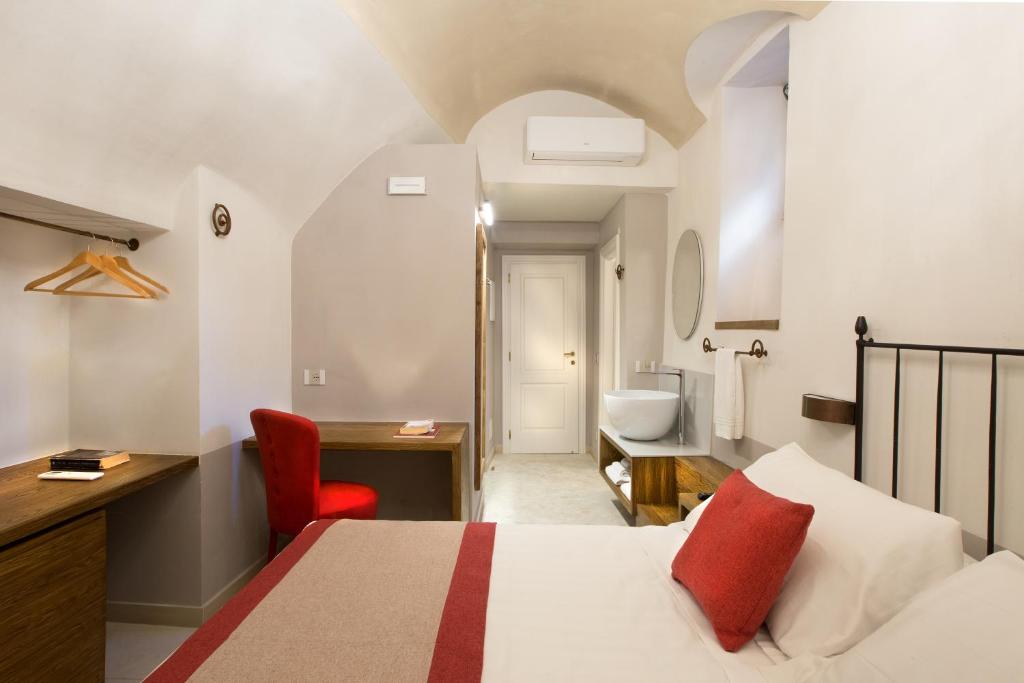 a hotel room with a bed and a desk and a bathroom at Dimora del Leone Gaeta in Gaeta