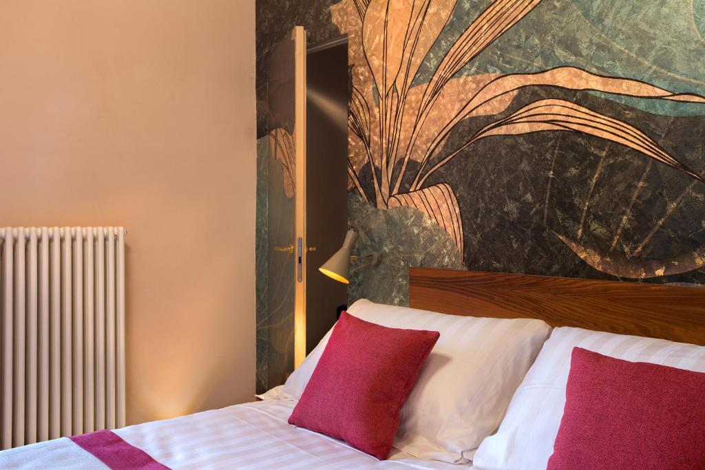 a bedroom with a bed with red and white pillows at Dimora del Leone Gaeta in Gaeta
