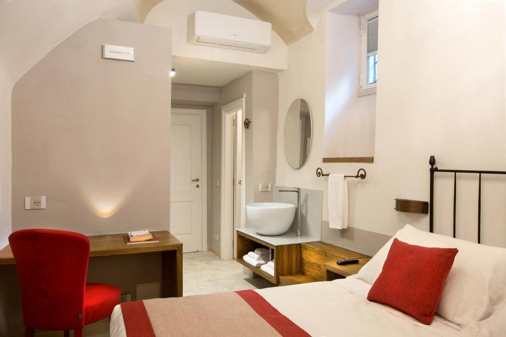 a bedroom with a bed and a bathroom with a sink at Dimora del Leone Gaeta in Gaeta