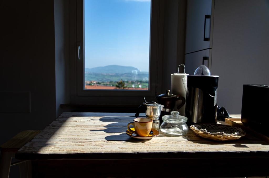 uma mesa com chávenas de café com uma janela em Finestra sul mare em Recanati
