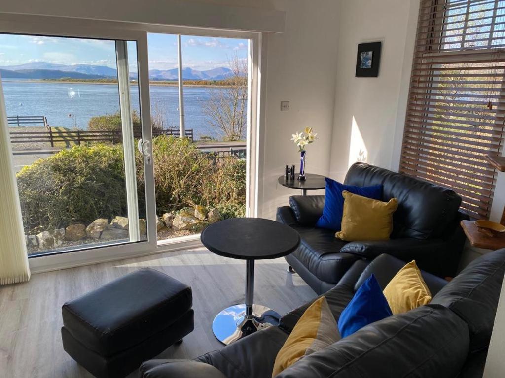 a living room with a couch and a view of the water at Ards House Self catering apartment with sea views in Oban