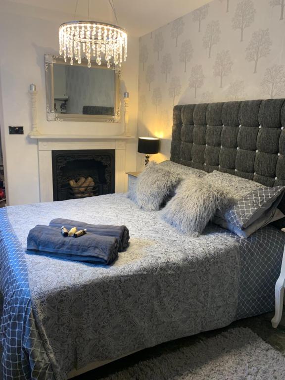 um quarto com uma cama com almofadas e uma lareira em The Courtyard em Wells