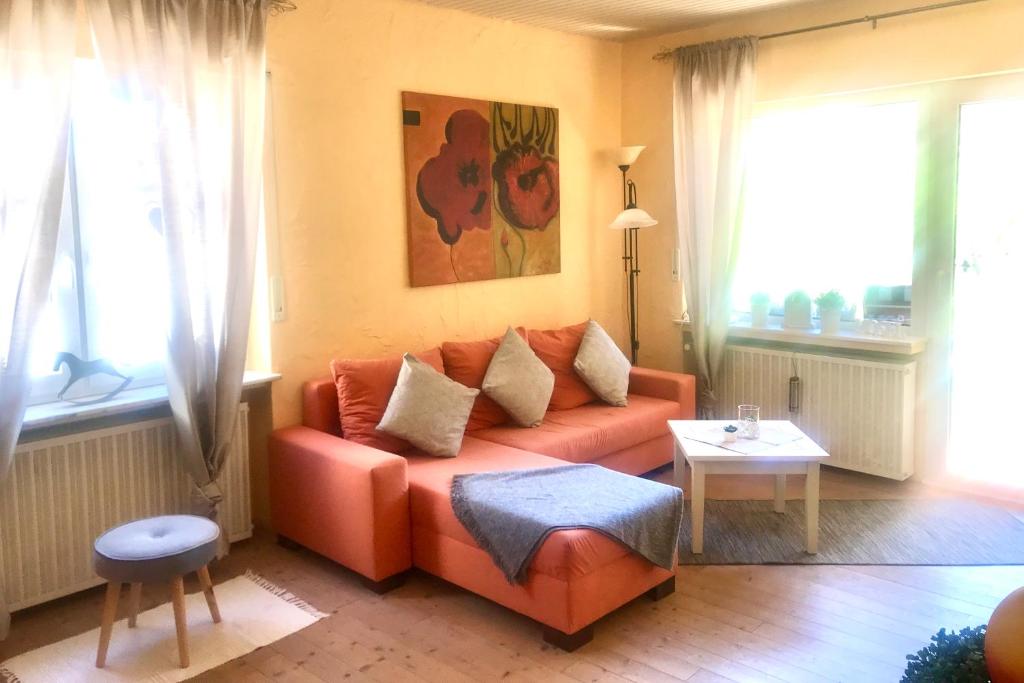 ein Wohnzimmer mit einem orangenen Sofa und einem Tisch in der Unterkunft Ferienwohnung Mosel in Valwig