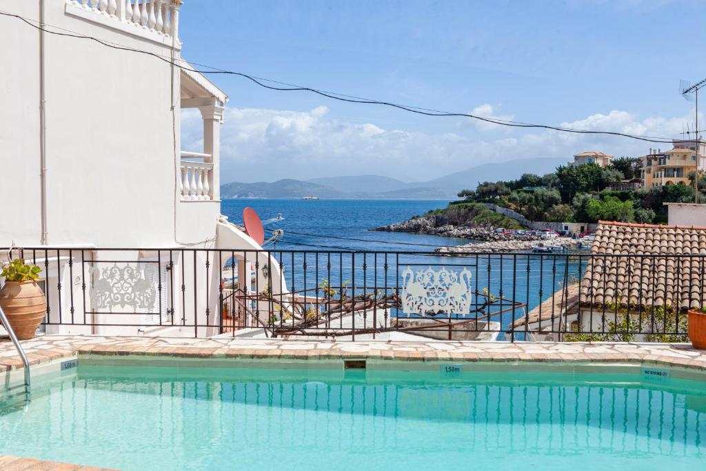 a swimming pool with a view of the ocean at Limani Apartments in Kassiopi