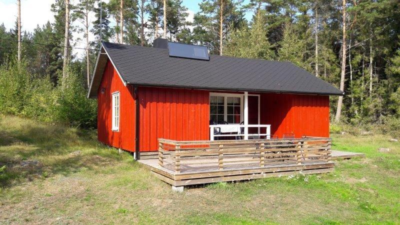a red cabin with a solar panel on top of it at Mellangårds stugor - Första stugan in Föglö