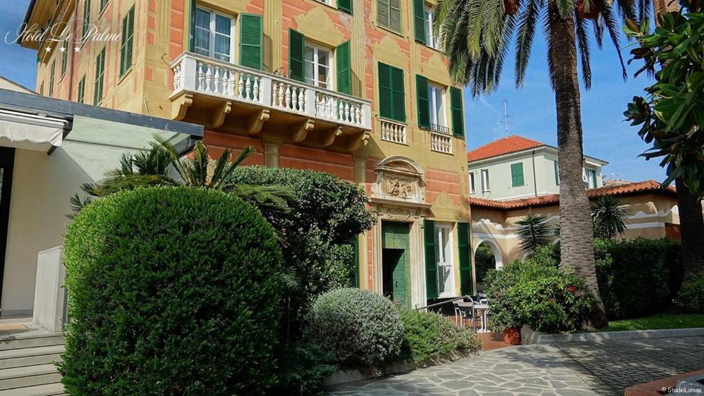 ein großes Gebäude mit einem Balkon und einer Palme in der Unterkunft Hotel Le Palme in Varraze