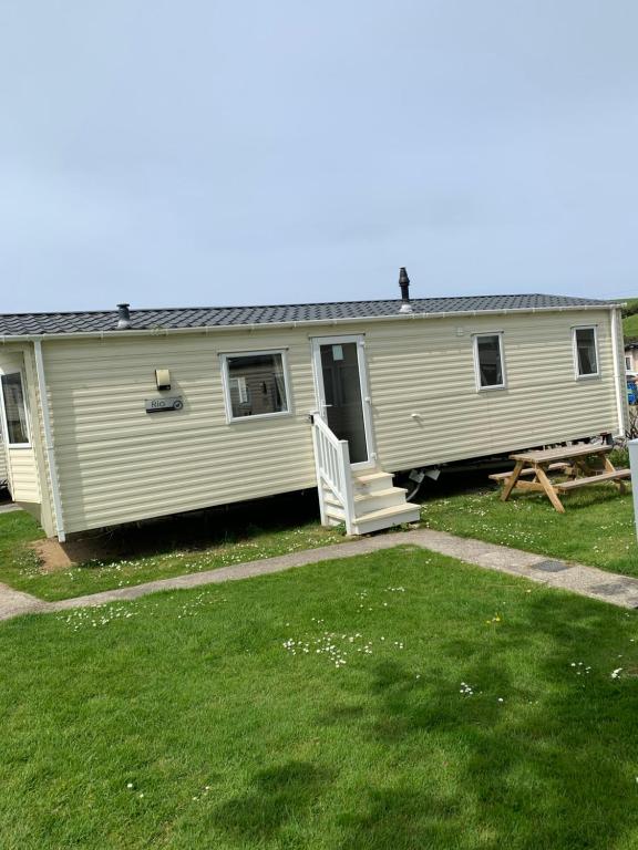 a mobile home with a porch and a picnic table at Newquay Bay Resort 63 in Newquay Bay Resort