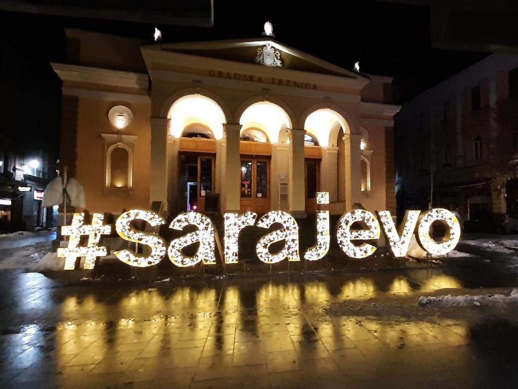 Ein Gebäude mit dem Wort Sarajevo leuchtet nachts in der Unterkunft Sarajevo Bulevar in Sarajevo