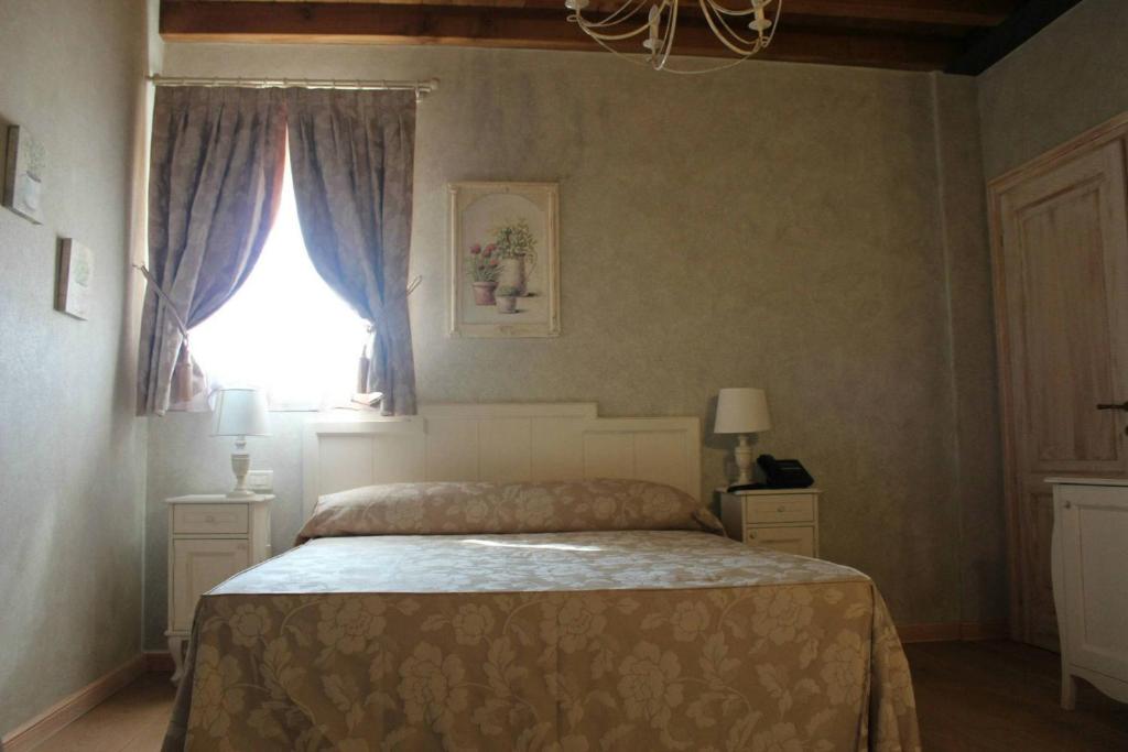 a bedroom with a bed and a window at Relais Mondotella in Pozzolengo