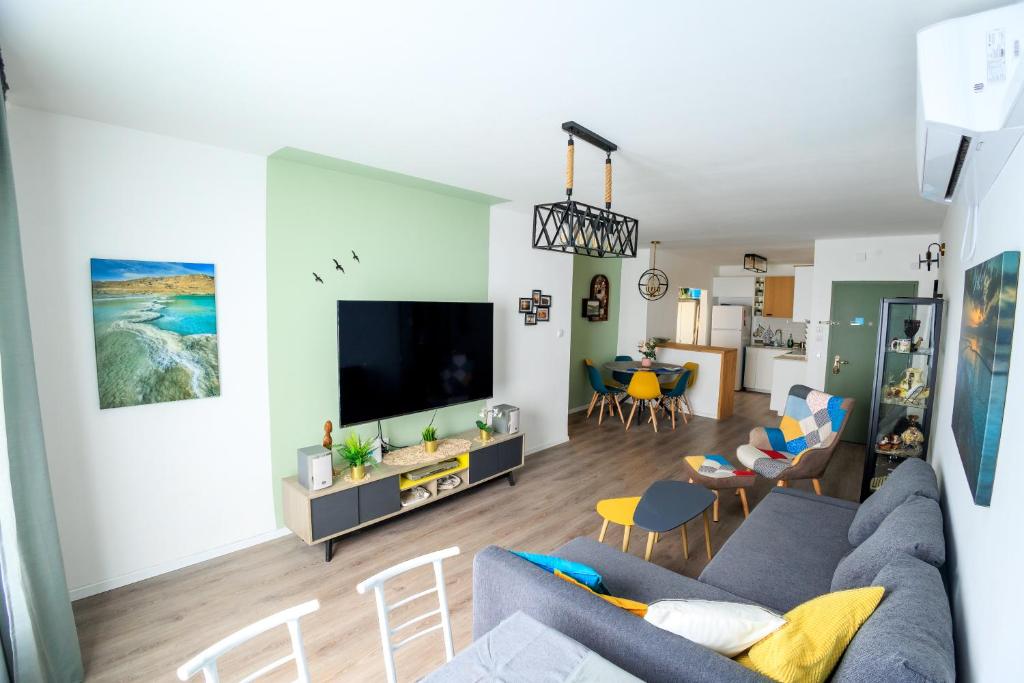 ein Wohnzimmer mit einem Sofa und einem TV in der Unterkunft Mandy's Place - By Soroka Medical Center and BGU in Be’er Scheva