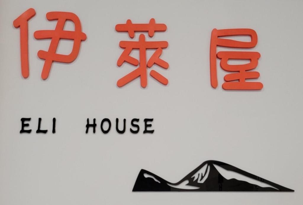 een bord voor het huis en een foto van een schoen bij Eli House in Toucheng