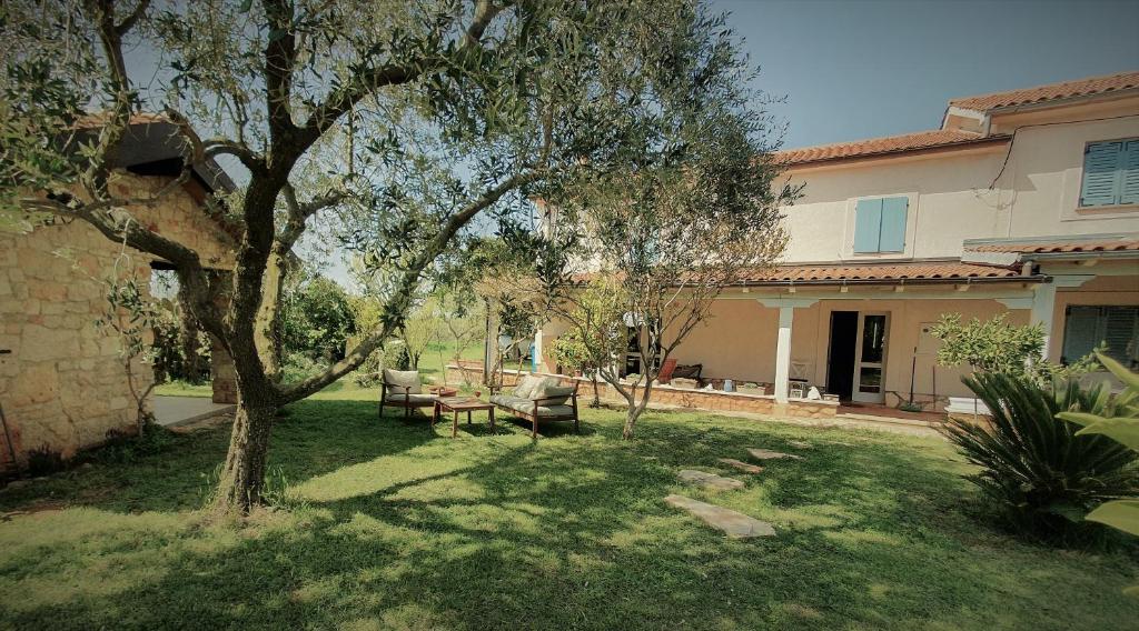 een tuin met een tafel en een boom voor een huis bij House Nono Bepo in small Istrian village - Kuca Nono Bepo u mirnom istarskom selu in Brtonigla
