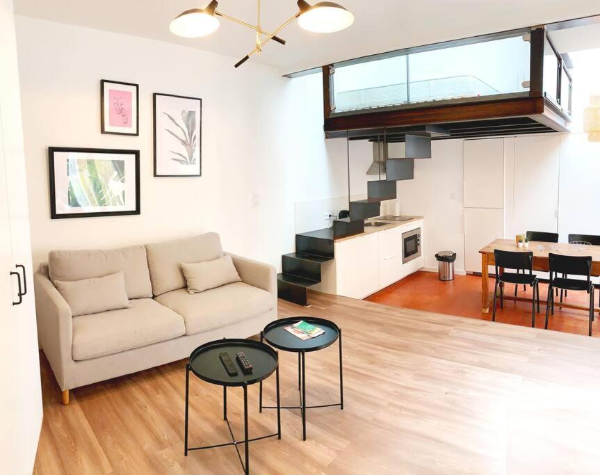ein Wohnzimmer mit einer Couch und Tischen in einem Raum in der Unterkunft L'atypique in Hyères
