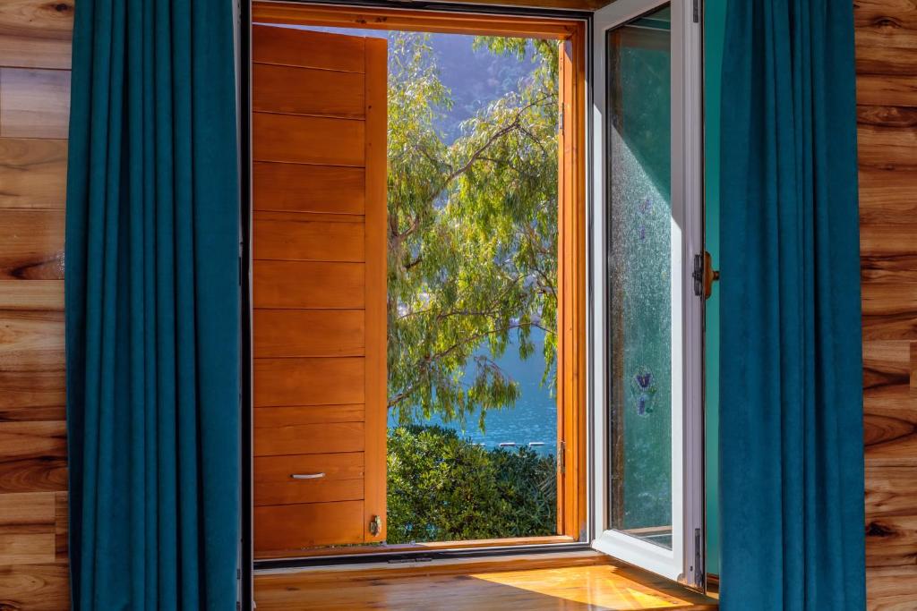 een open raam met uitzicht op de oceaan bij Waterfront Apartments in Kotor
