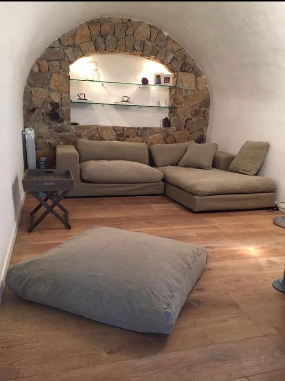 uma sala de estar com um sofá e uma parede de pedra em Casa Divota au cœur d’un village paisible em Santa-Reparata-di-Balagna